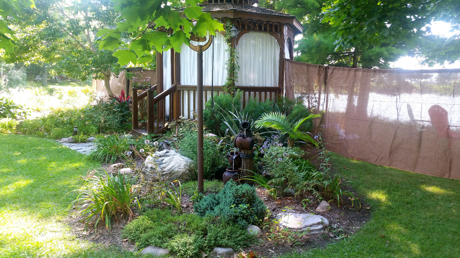 The flowerbed with our little rope and timber fountain